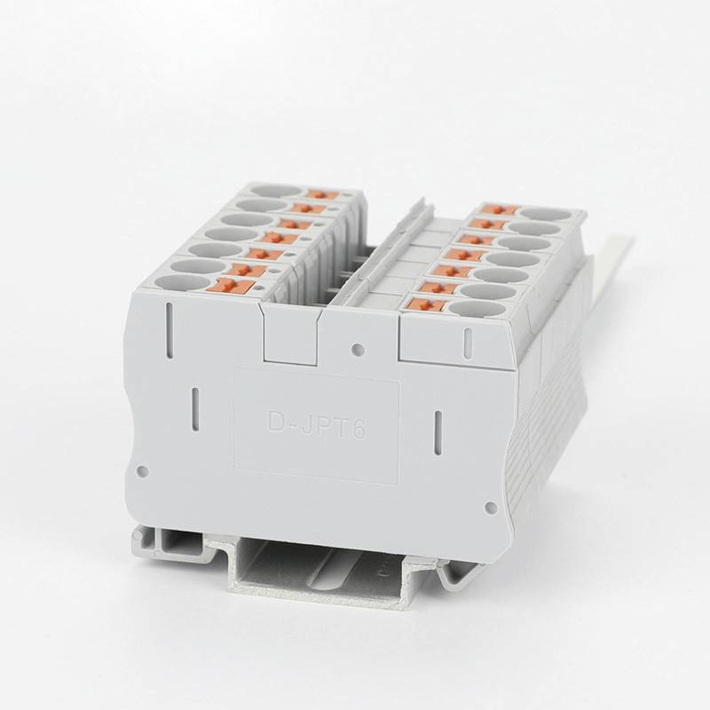 Un modulo di morsetti elettrici grigio con leve arancioni, utilizzato per collegare cavi all'interno di un quadro elettrico.