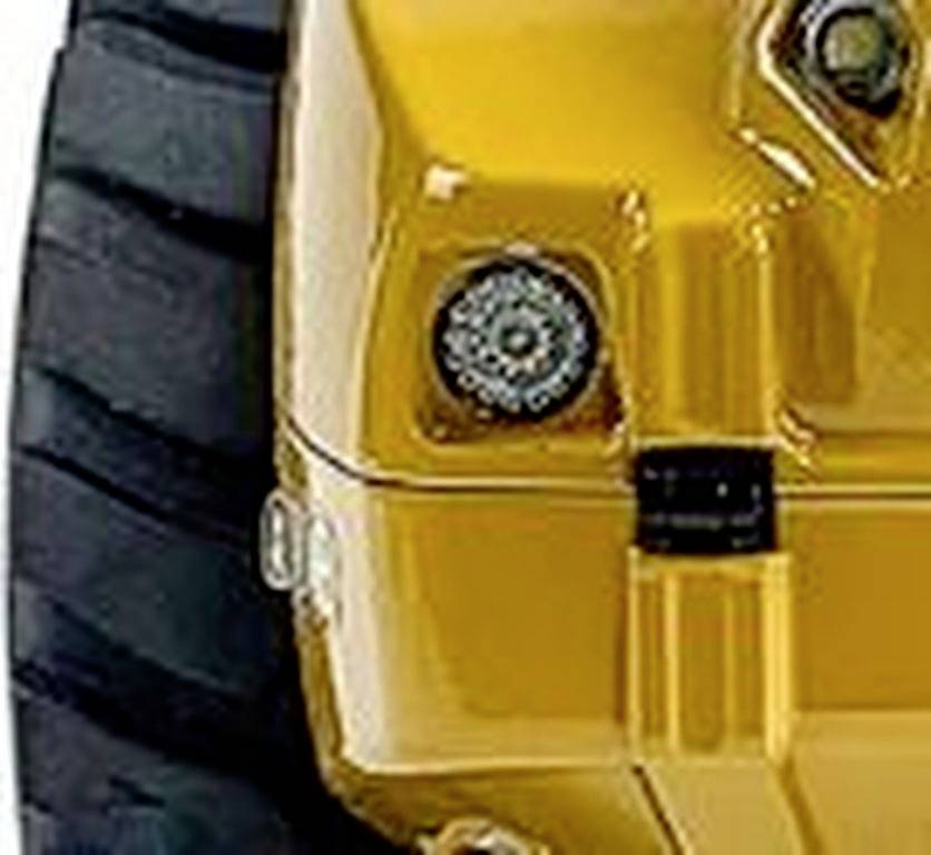 Primo piano di un componente giallo di un veicolo con pneumatici grandi e dettagli meccanici visibili.