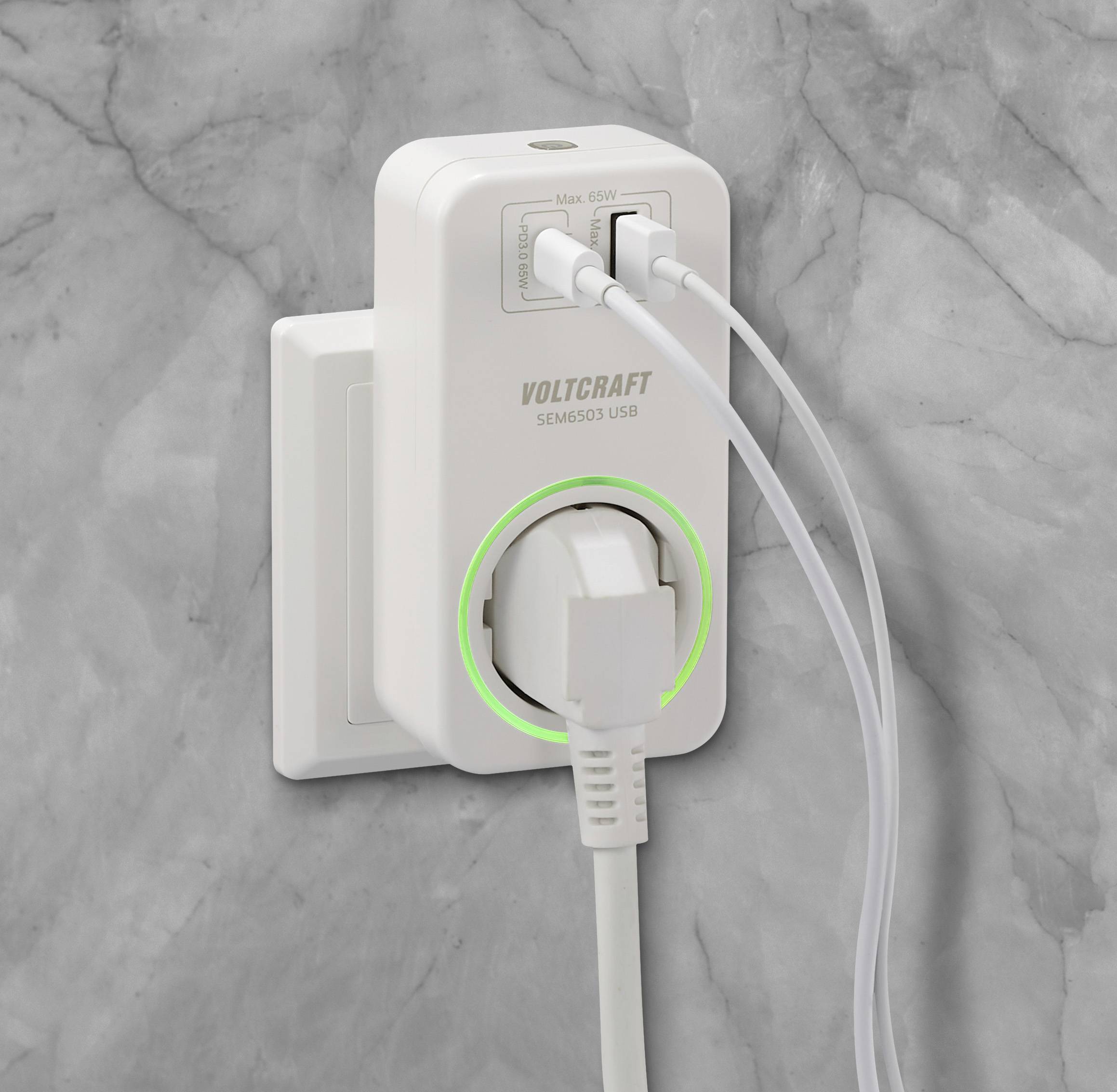 Un caricabatterie bianco con più porte è inserito in una presa elettrica grigia a muro. Due cavi USB sono collegati.