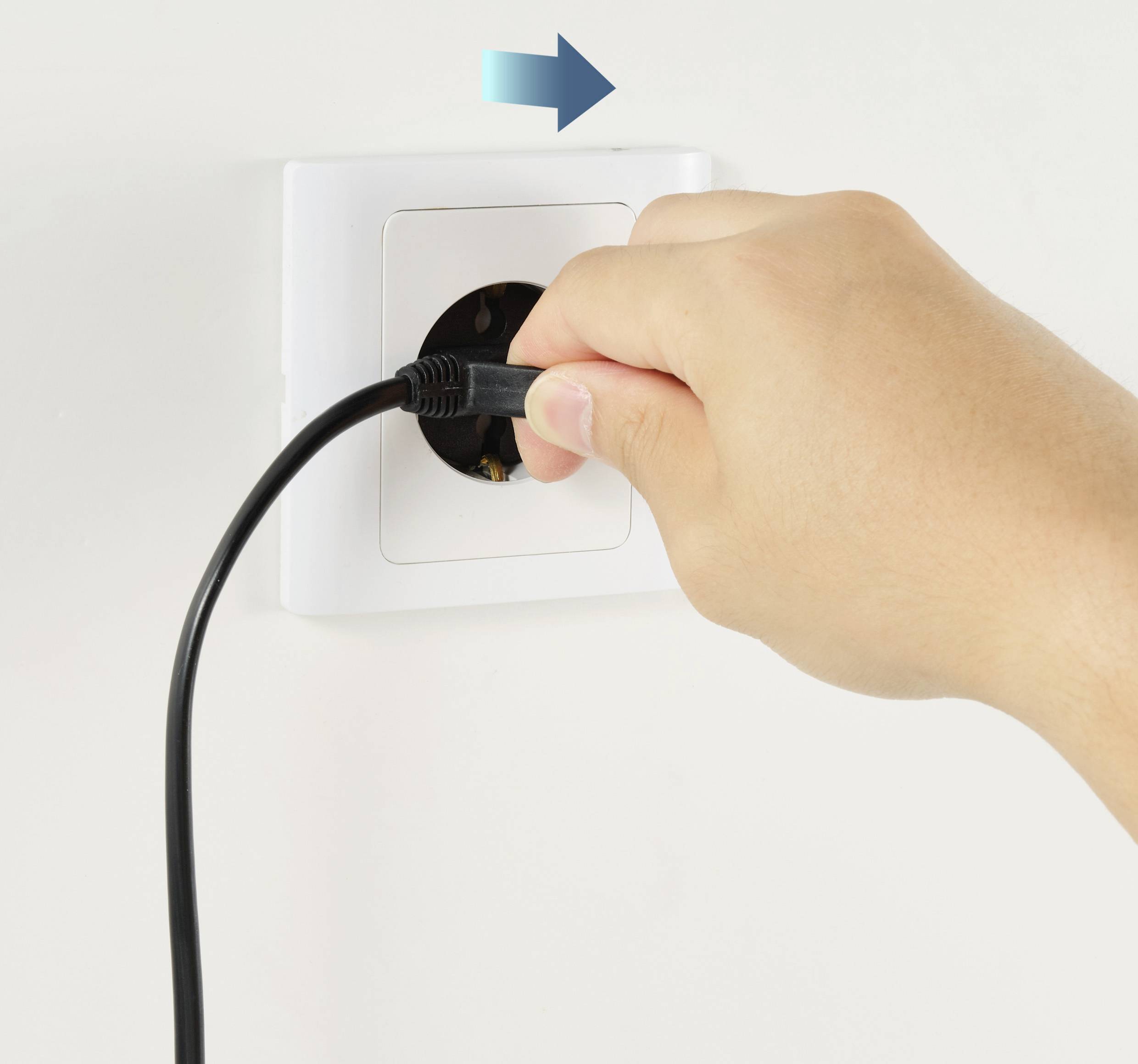 Una mano inserisce una spina in una presa elettrica. Una freccia indica la direzione di inserimento.