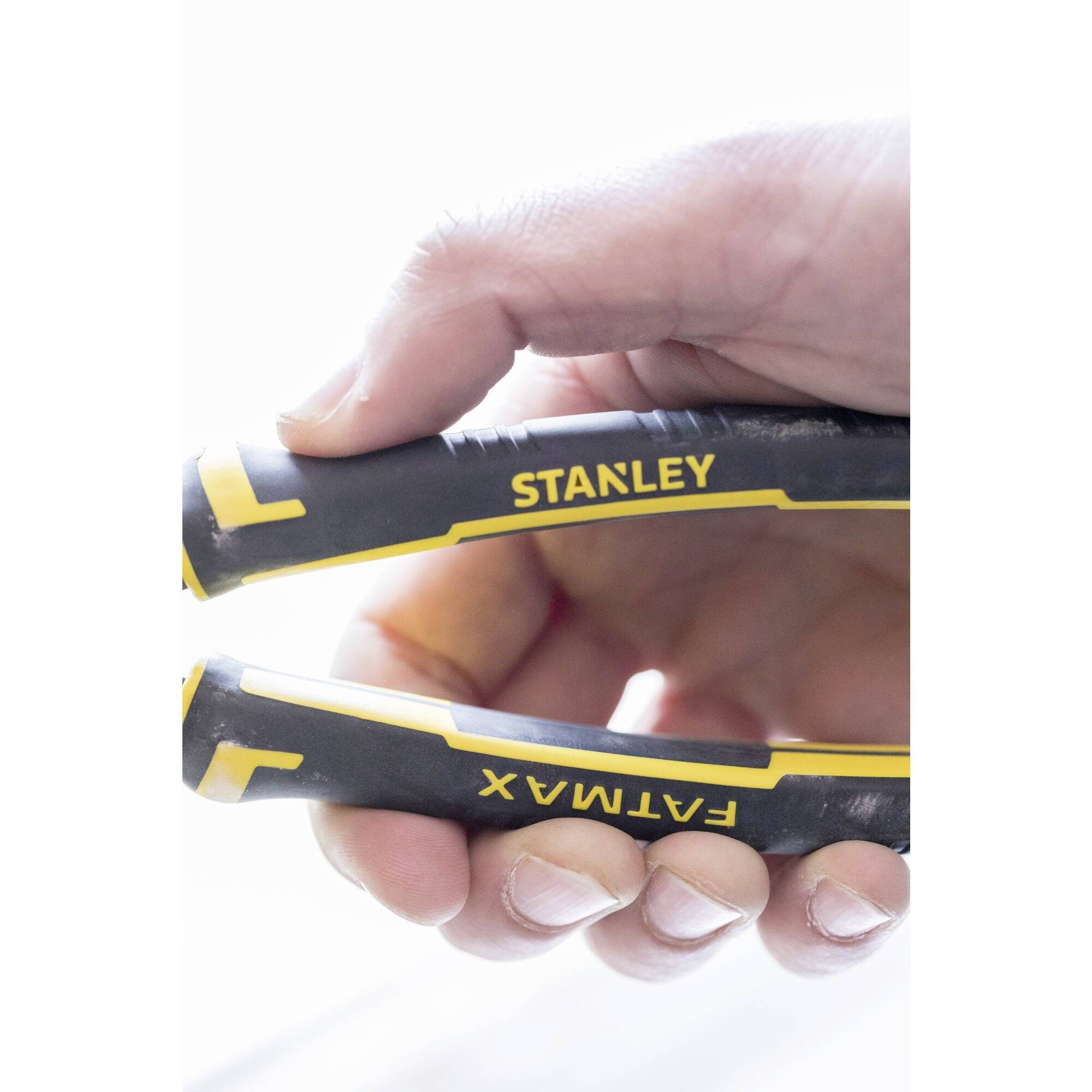 Una mano tiene una leva Stanley Fatmax gialla e nera, con fuoco sui manici.