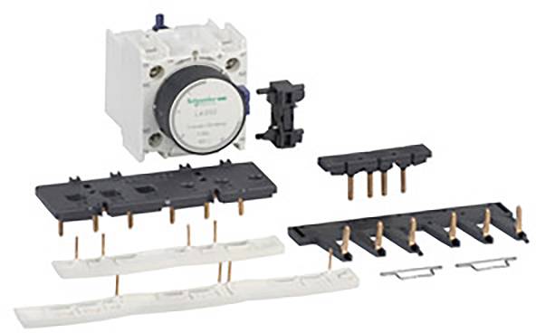Un insieme di componenti elettrici, tra cui un contattore e diverse morsettiere, su uno sfondo bianco.