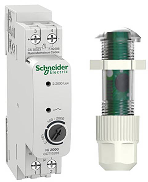Un modulo di controllo di Schneider Electric con quadranti per impostazioni da 2-2000 Lux, affiancato da un sensore cilindrico.