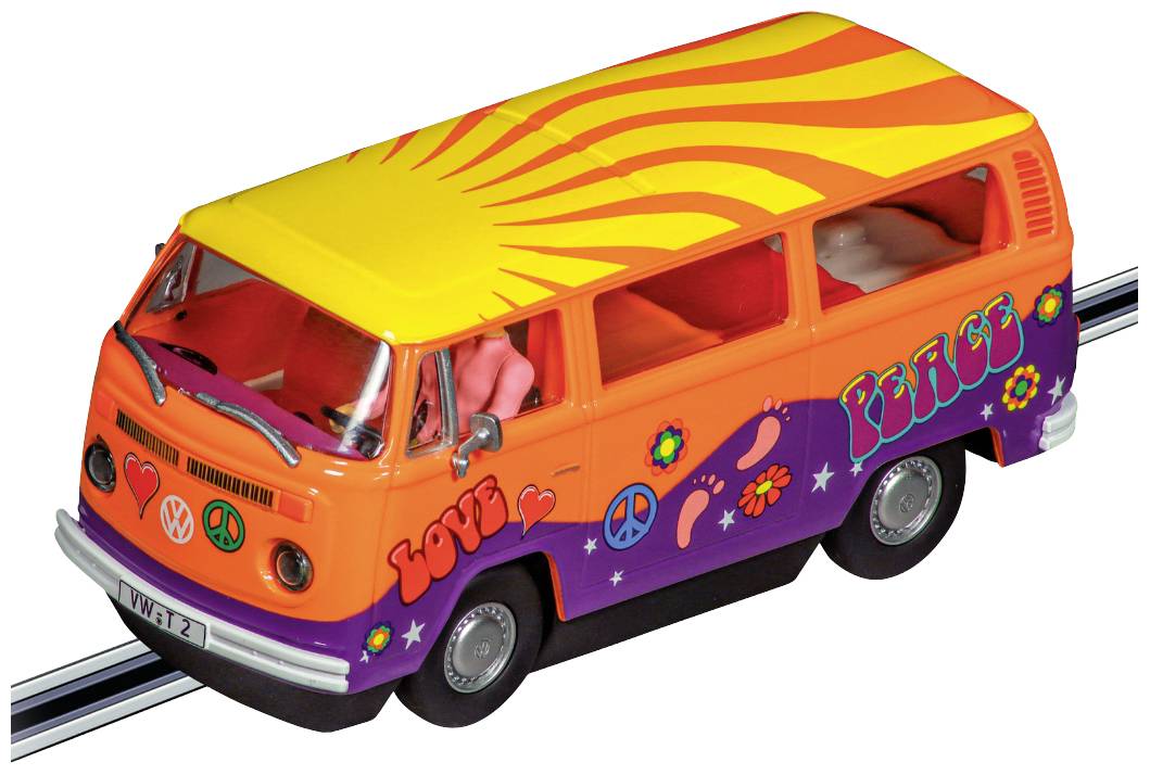 Un autobus giocattolo in stile hippie con le parole 'Love' e 'Peace', decorato con fiori, cuori e simboli di pace, su un plastico ferroviario.