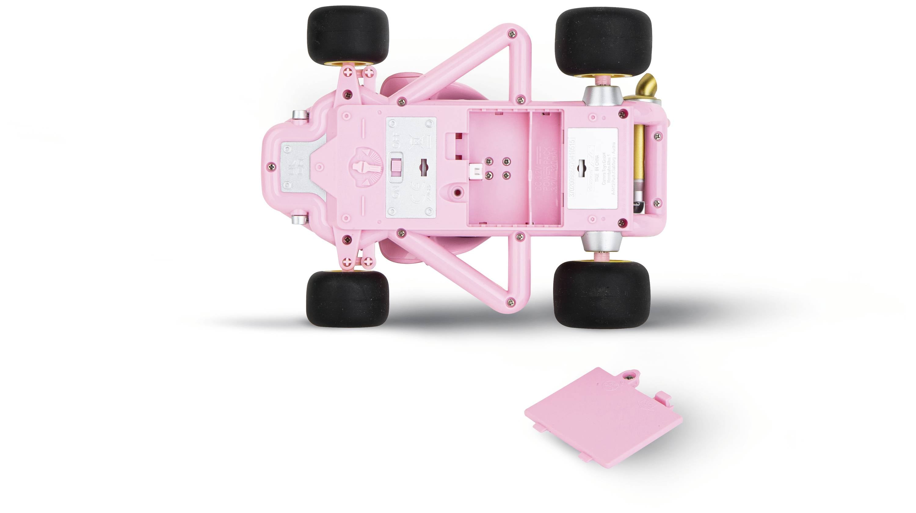 Un'auto modello rosa vista dal basso, che mostra il telaio e le quattro ruote. Accanto è posizionata una piastra di base.