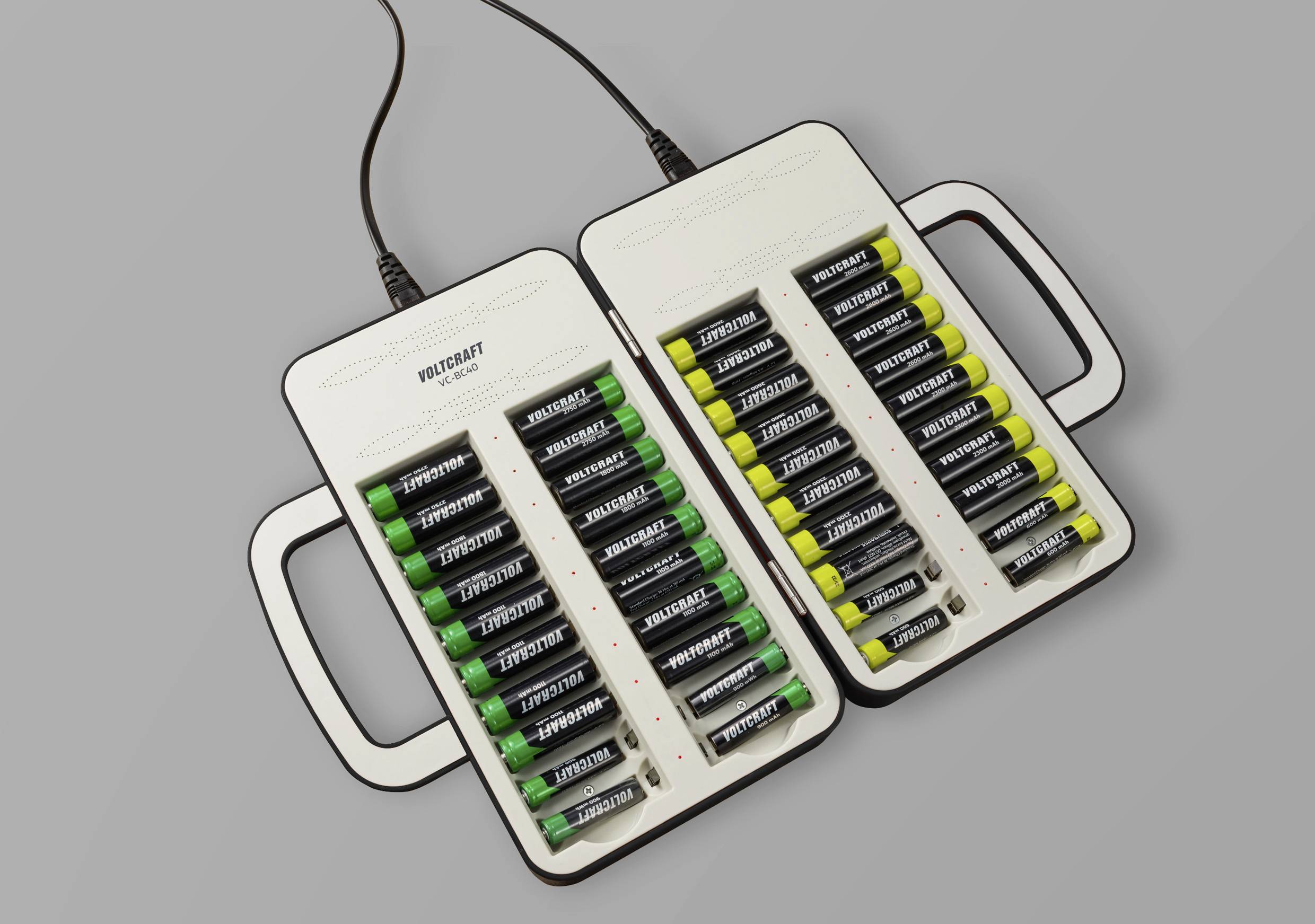 Due caricabatterie con numerose batterie AA inserite, uno verde e uno nero, collegati con cavi per la ricarica.
