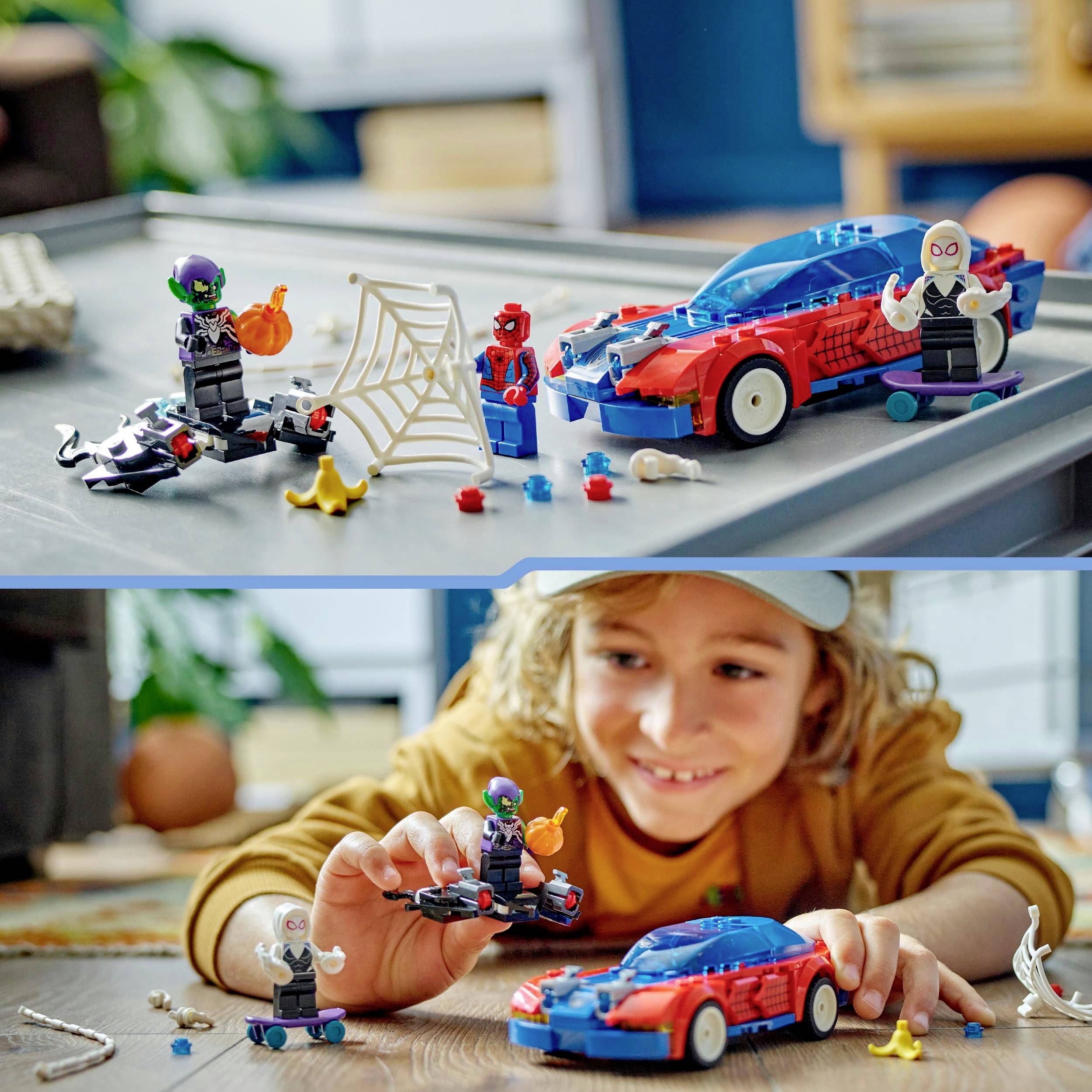 Un bambino gioca con macchinine colorate e figure su un tavolo. Una figura tiene in mano una rete di plastica. Sullo sfondo sfocato.