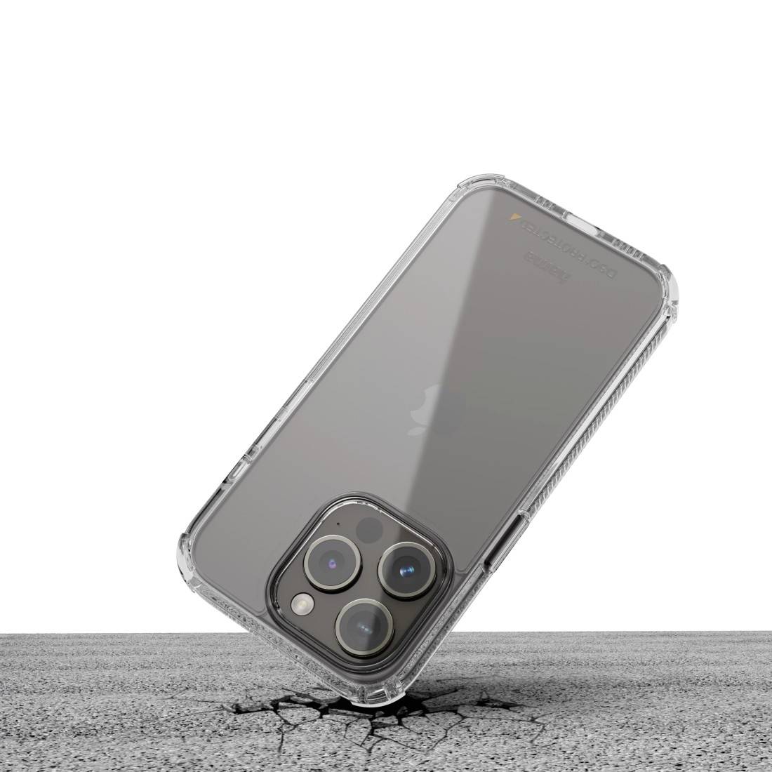 Cover trasparente per smartphone protegge il dispositivo con tripla fotocamera da danni; poggiata su superficie screpolata.