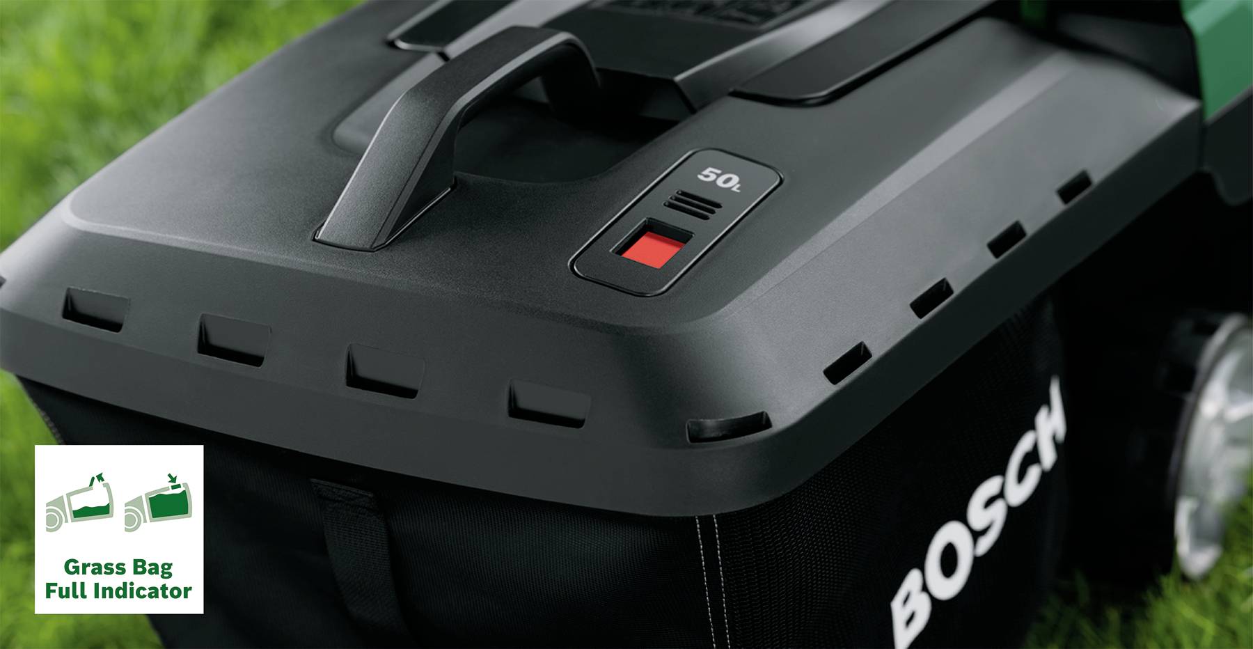 Tagliaerba con interruttore rosso e simbolo del cestello raccoglierba pieno su un prato verde.