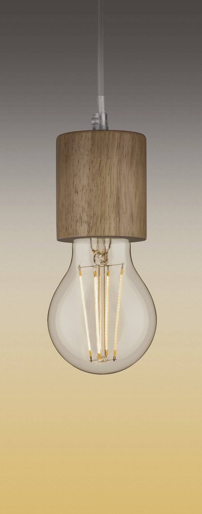 Una lampadina con base in legno pende e illumina debolmente in un ambiente caldo e giallognolo.