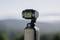Fotocamera compatta nera con gimbal su sfondo sfocato; adatta per viaggi e vlogging.