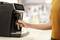 Una persona sta utilizzando una macchina da caffè moderna in una cucina. La mano sta azionando la leva per preparare il caffè.