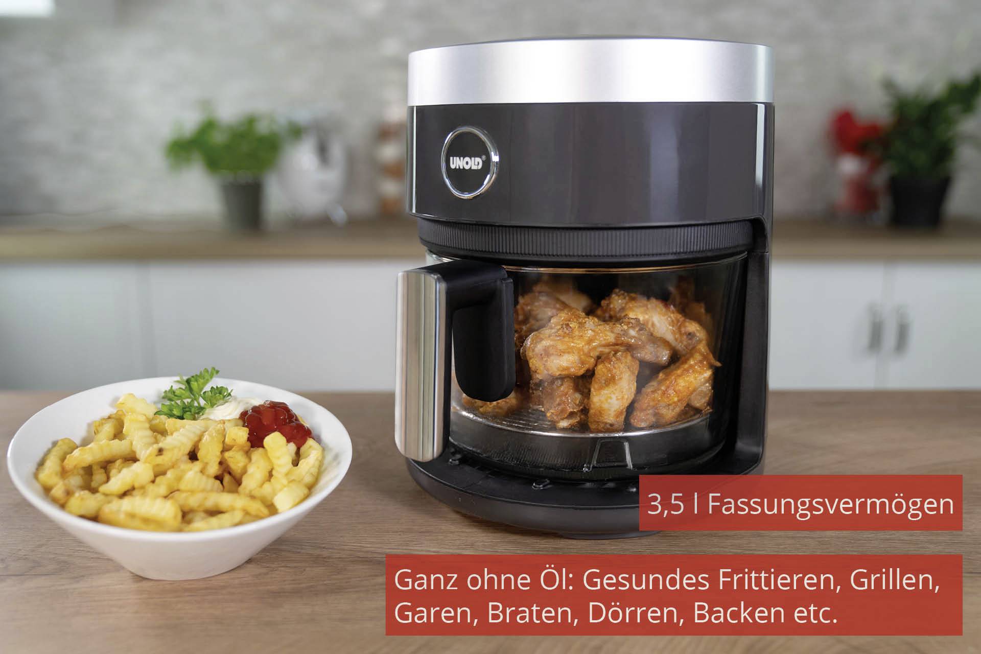 Friggitrice ad aria con pollo fritto all'interno, accanto a un piatto di patatine fritte. Testo: '3,5 l di capacità. Completamente senza olio.'