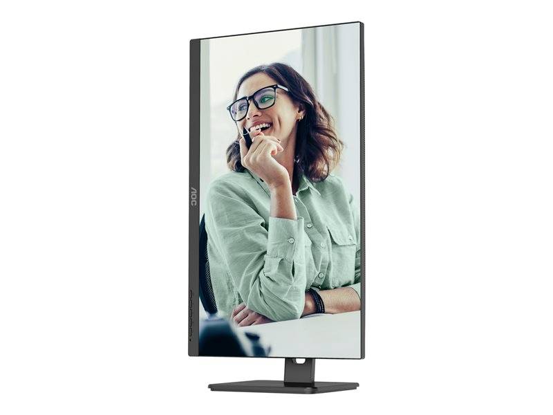 Una donna con gli occhiali sorride e guarda a sinistra, mentre tiene in mano una penna. Il monitor è in formato verticale.