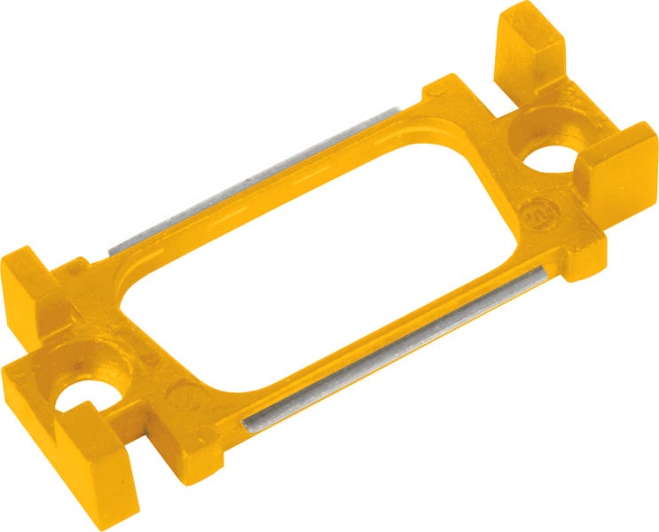 Un pezzo rettangolare giallo in plastica con inserti metallici e quattro angoli sporgenti, probabilmente pensato come supporto o staffa.