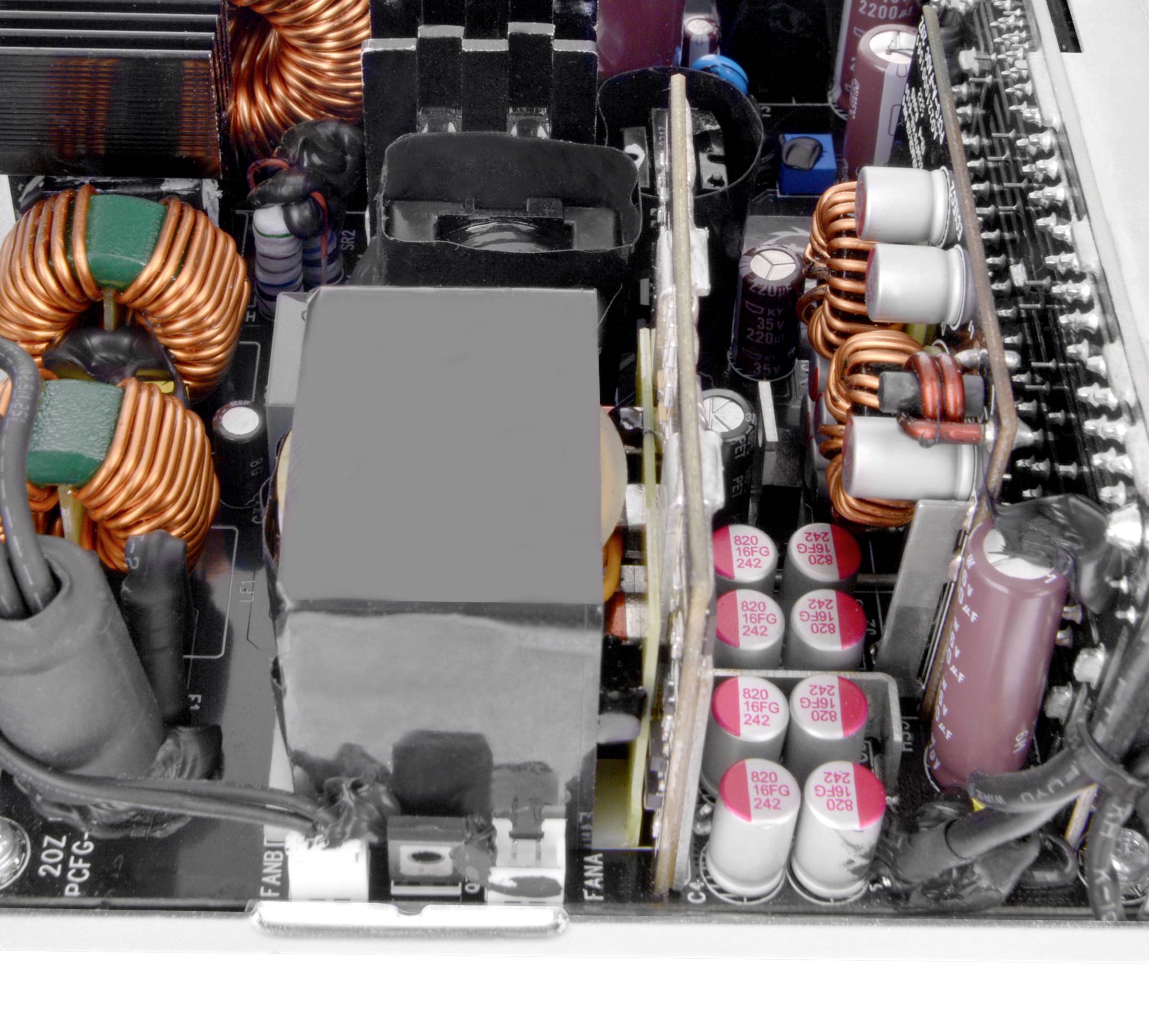 Componenti elettroniche in un alimentatore per computer con induttanze, condensatori e dissipatori di calore utilizzati per l'alimentazione elettrica.