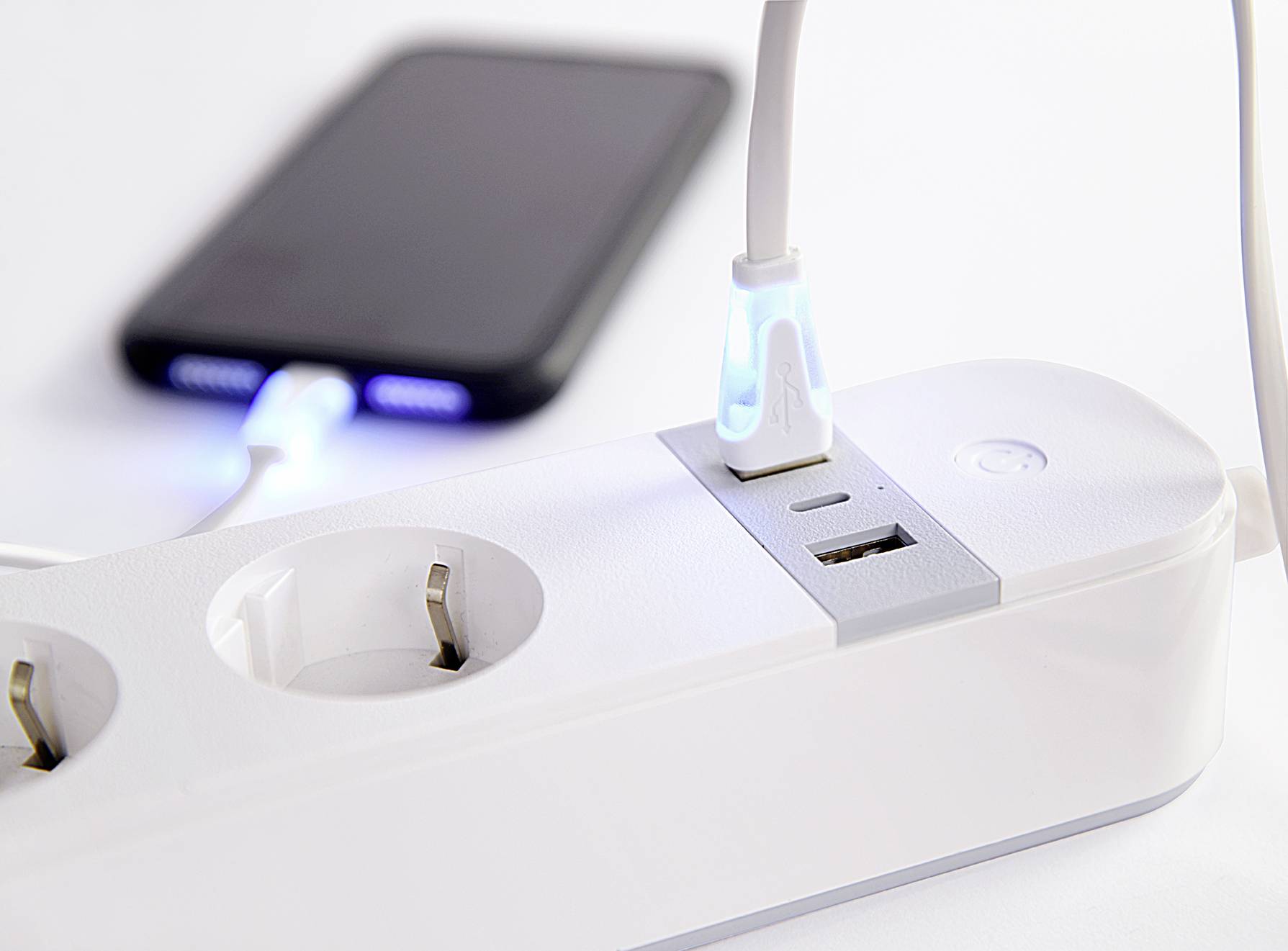 Uno smartphone si sta caricando su una multipresa con porte USB. Un cavo collega lo smartphone alla multipresa.