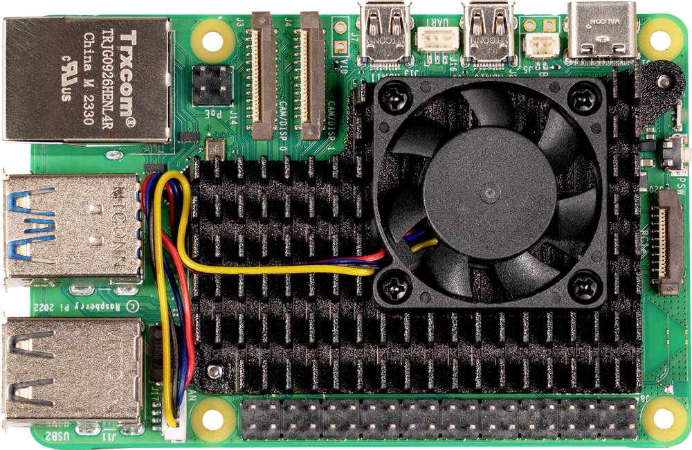 Un modulo computer monopiastra verde con dissipatore di calore, ventola e porte per USB, HDMI ed Ethernet, visto dall'alto.
