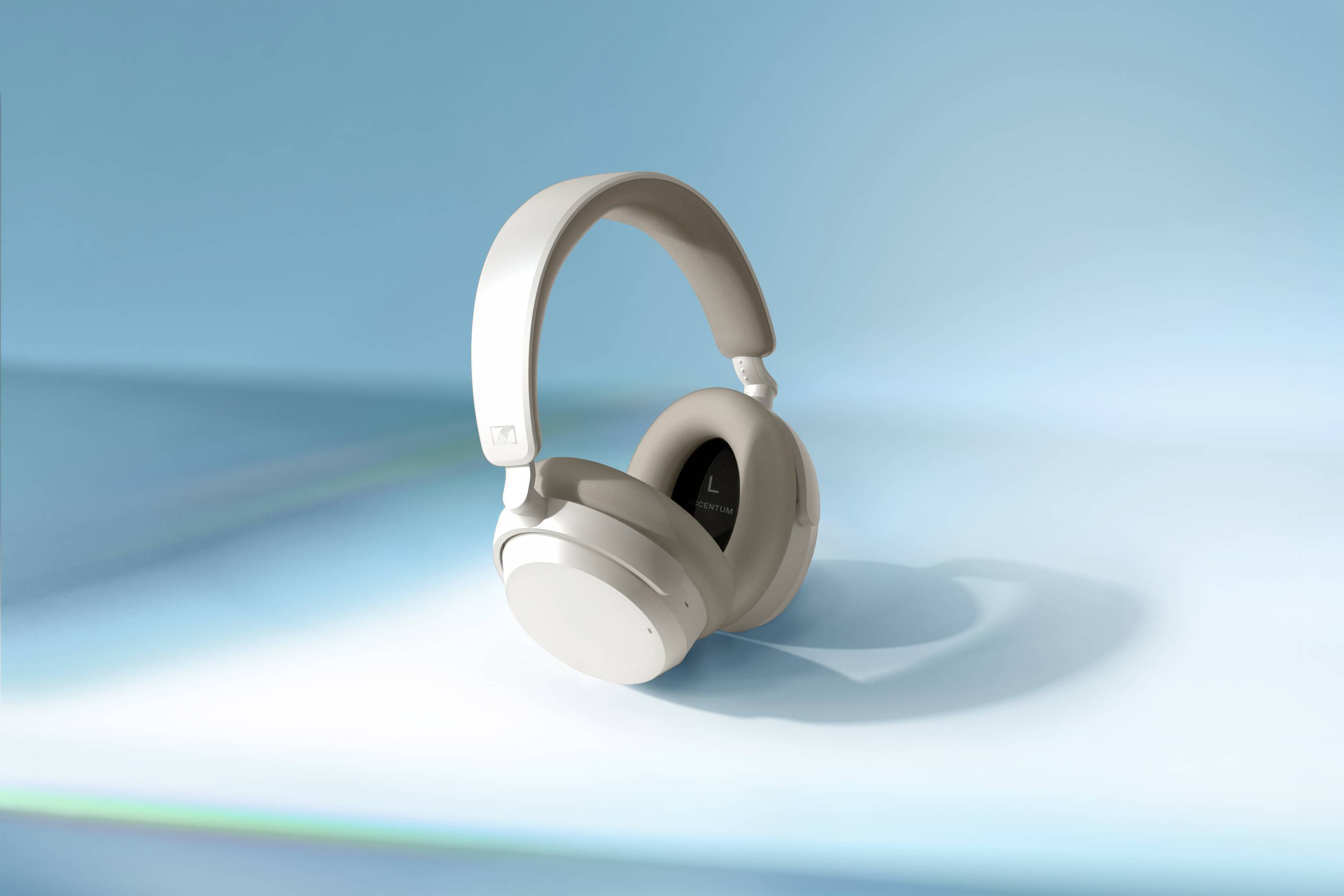 Cuffie wireless over-ear grigio chiaro su sfondo blu. Design moderno, nessun cavo visibile, ideali per l'ascolto di musica o audio.