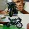 Un bambino costruisce una moto da corsa complessa con pezzi Lego. Qui sotto, il modello completato è posizionato su una scrivania.