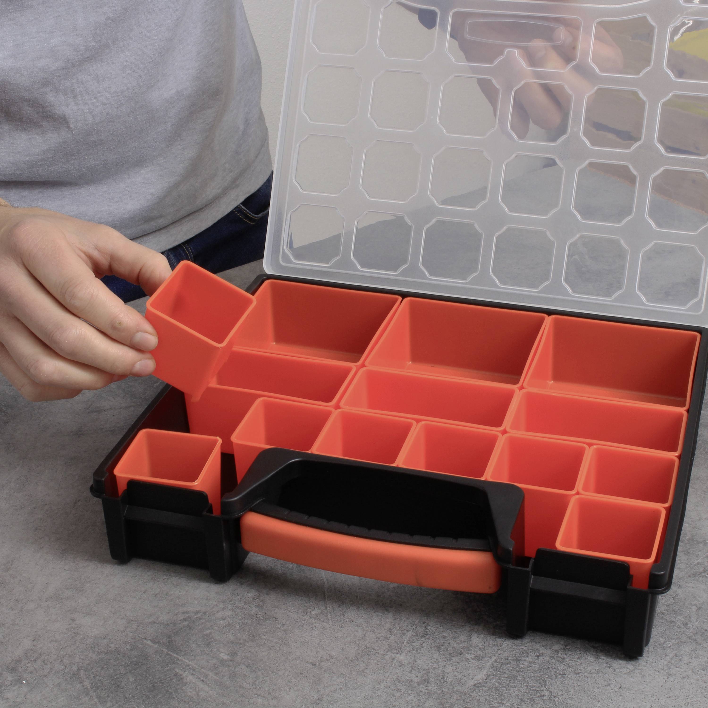 Una persona sta sistemando contenitori di plastica rossi in un organizer nero. L'organizer ha diversi scomparti e un coperchio trasparente.