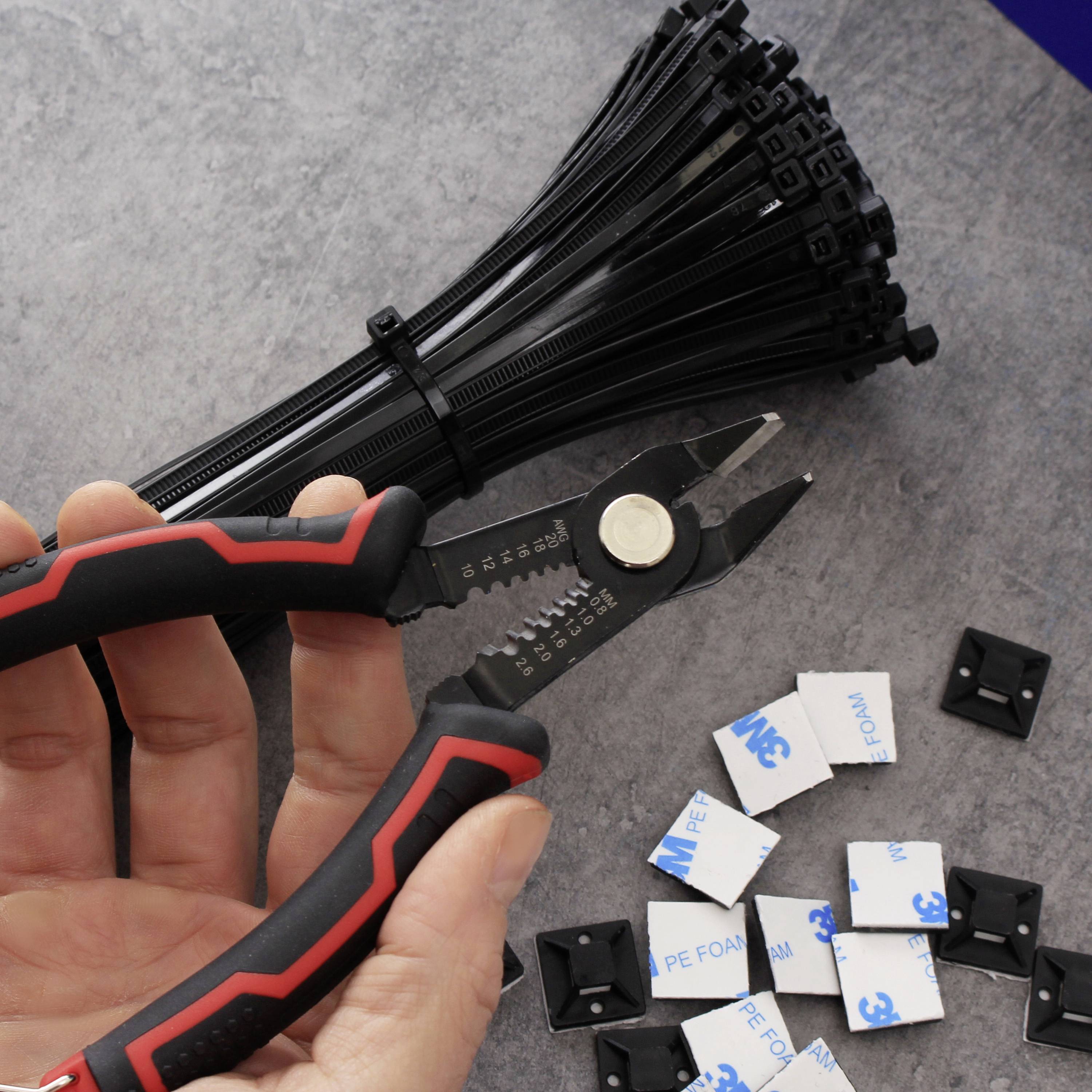 Una mano tiene un tronchese e taglia fascette nere. Sul tavolo ci sono diversi pad adesivi.