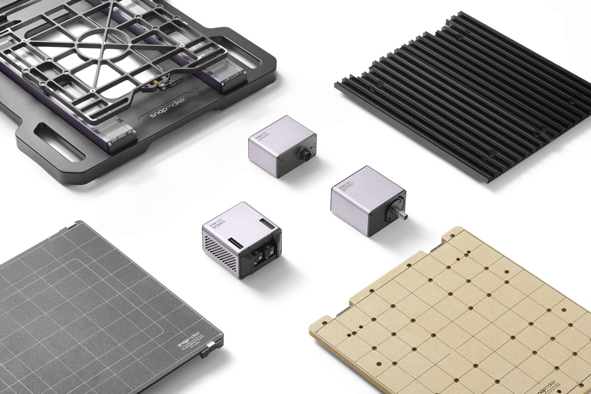 Un kit per taglio laser con due teste laser, una piastra metallica, una tavola in legno forata e supporti neri, su sfondo bianco.