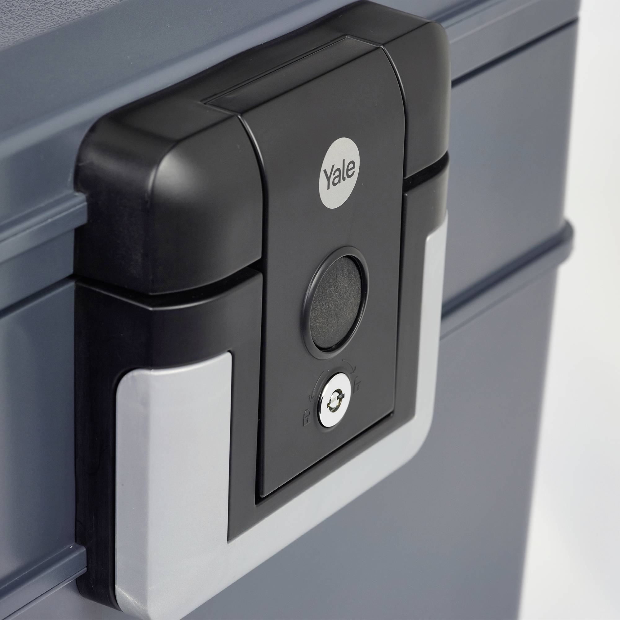 Un cassaforte sicura, grigia, con un lucchetto digitale nero e argentato che mostra uno scanner per impronte digitali e un buco della serratura.