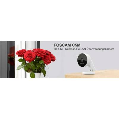 Telecamera di sorveglianza FOSCAM C5M 3K 5 MP dual-band Wi-Fi accanto a un mazzo di rose rosse su un tavolo.