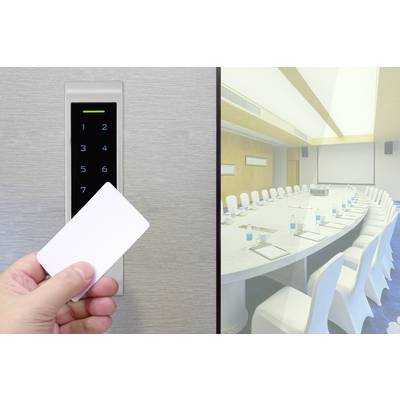 Una mano tiene un'carta di accesso davanti a una serratura elettronica. Sullo sfondo, una sala riunioni vuota con un grande tavolo e sedie.