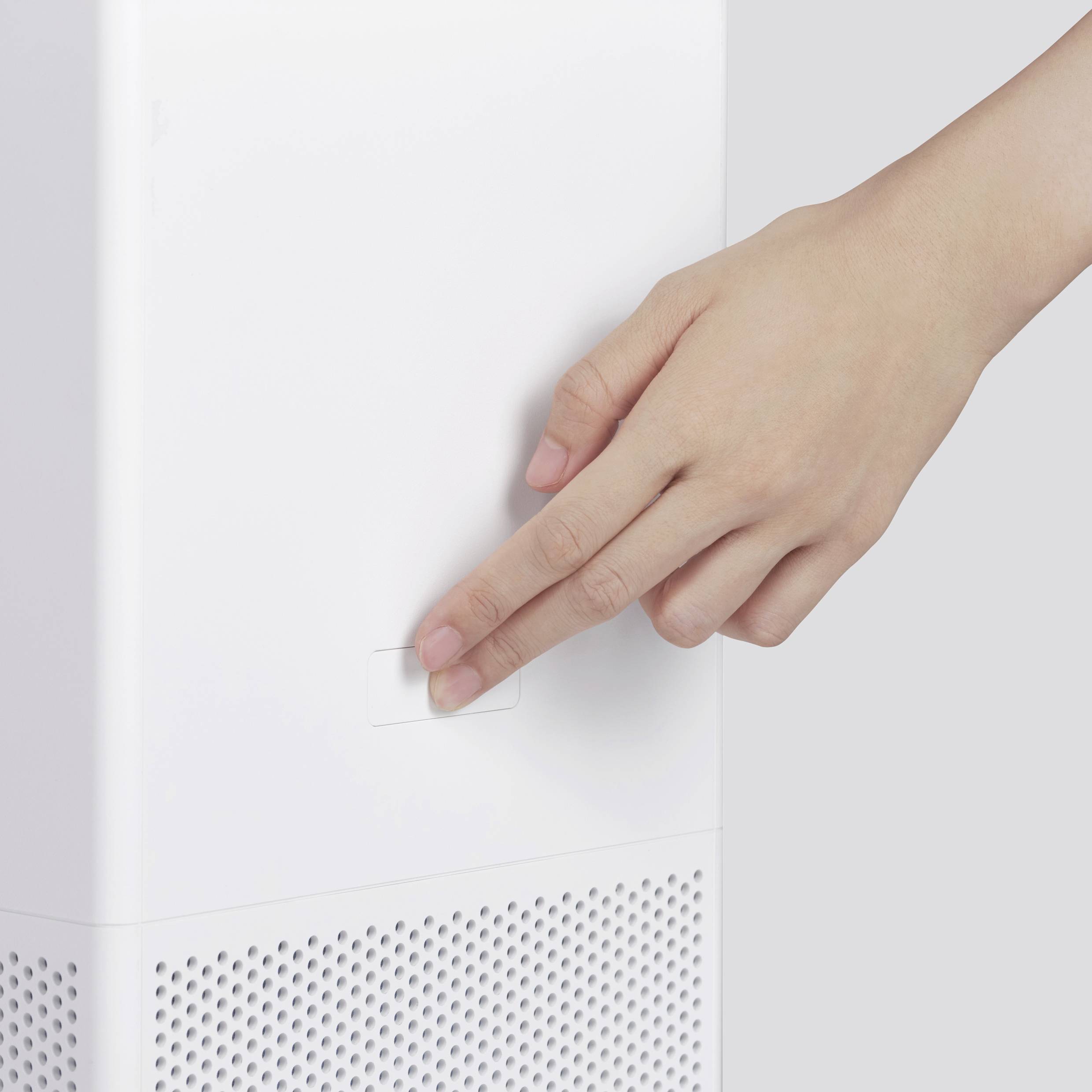 Una mano preme il pulsante di accensione di un purificatore d'aria.