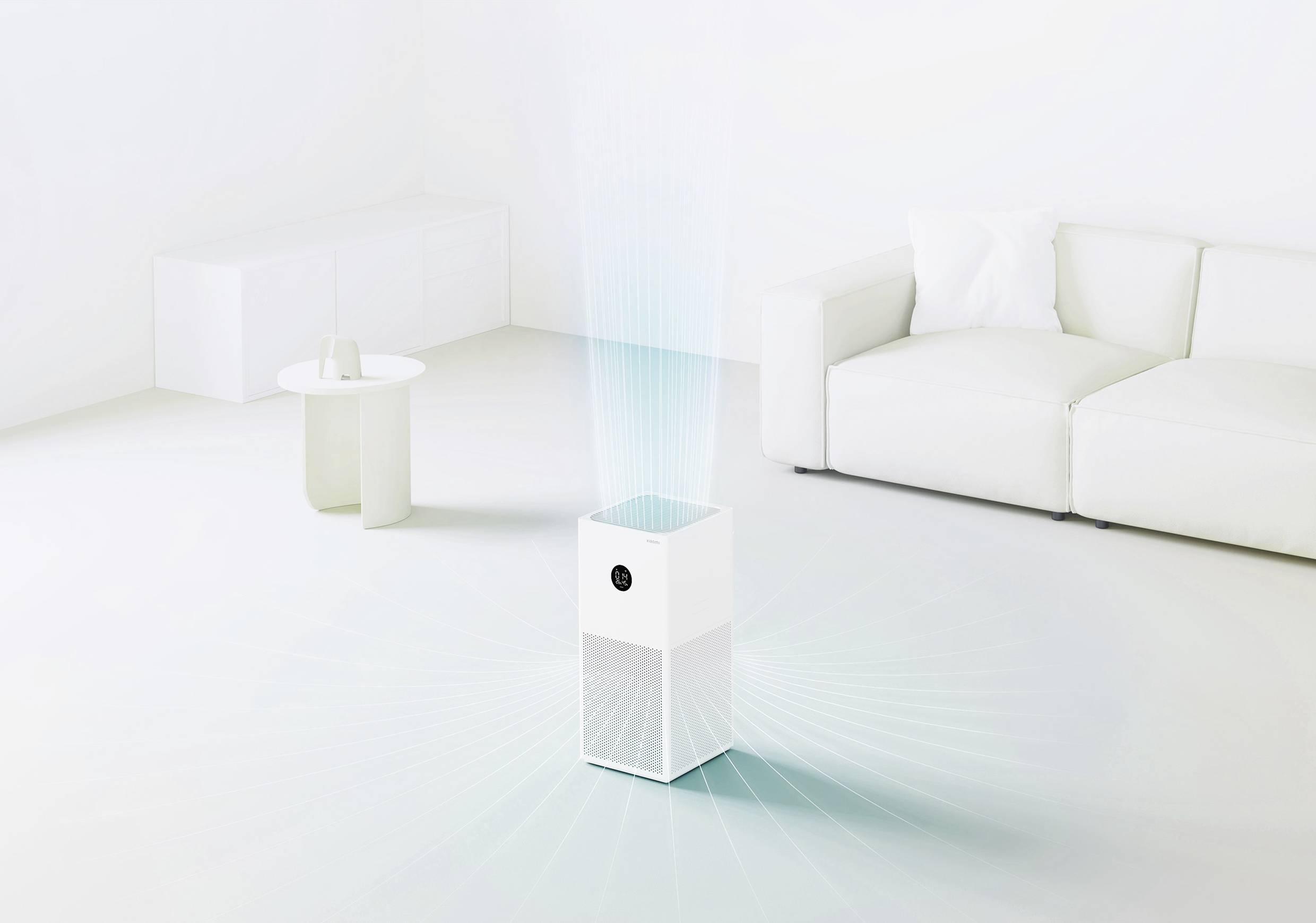 Un purificatore d'aria bianco è posizionato in un soggiorno luminoso e minimale, accanto a un divano e a un piccolo tavolo rotondo.