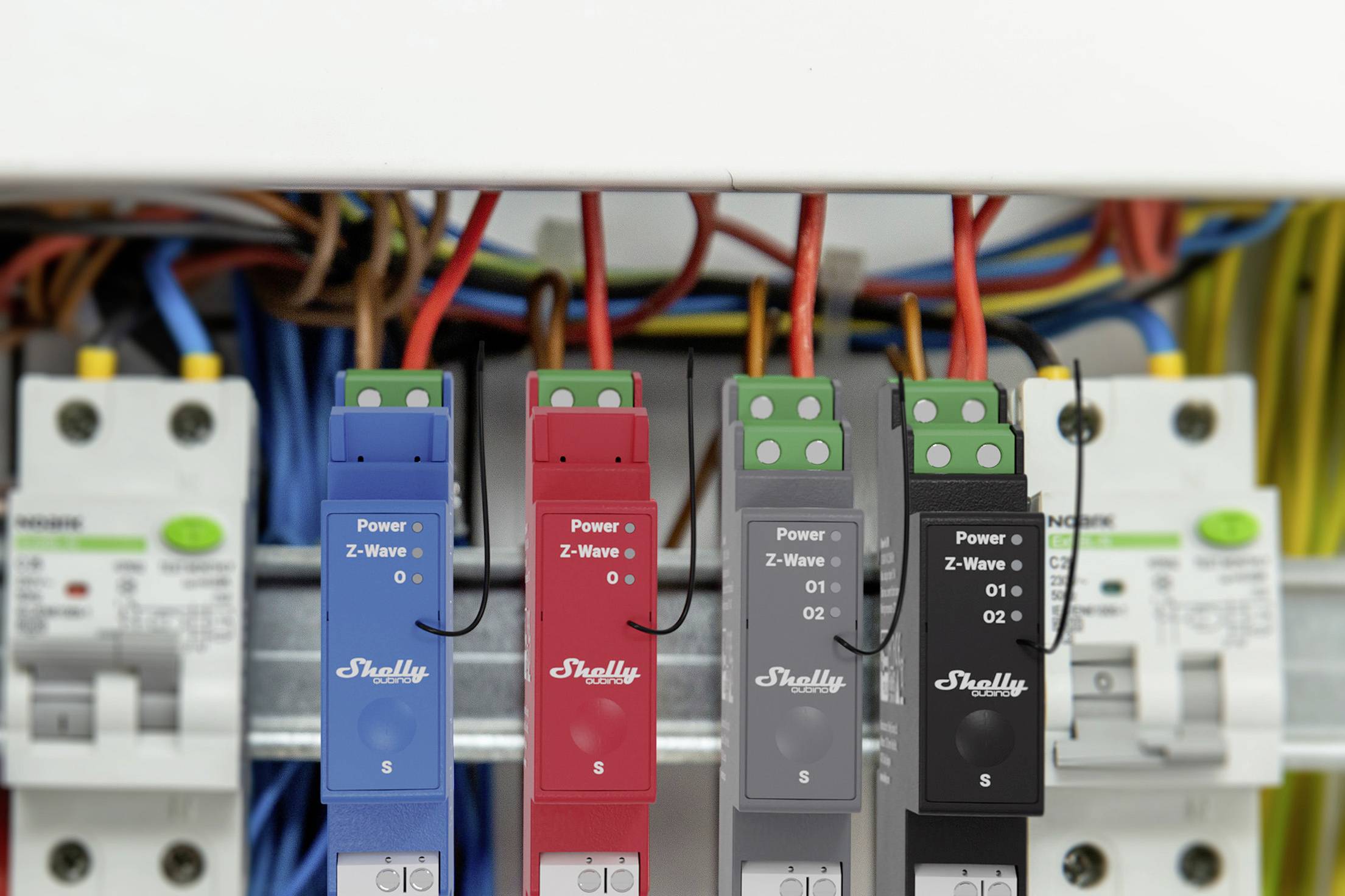 Una serie di interruttori elettronici e cavi in un quadro elettrico mostra moduli con codifica blu, rossa e nera con etichette.