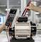 Una persona utilizza un multimetro per misurare valori elettrici su un motore industriale in un ambiente di laboratorio.