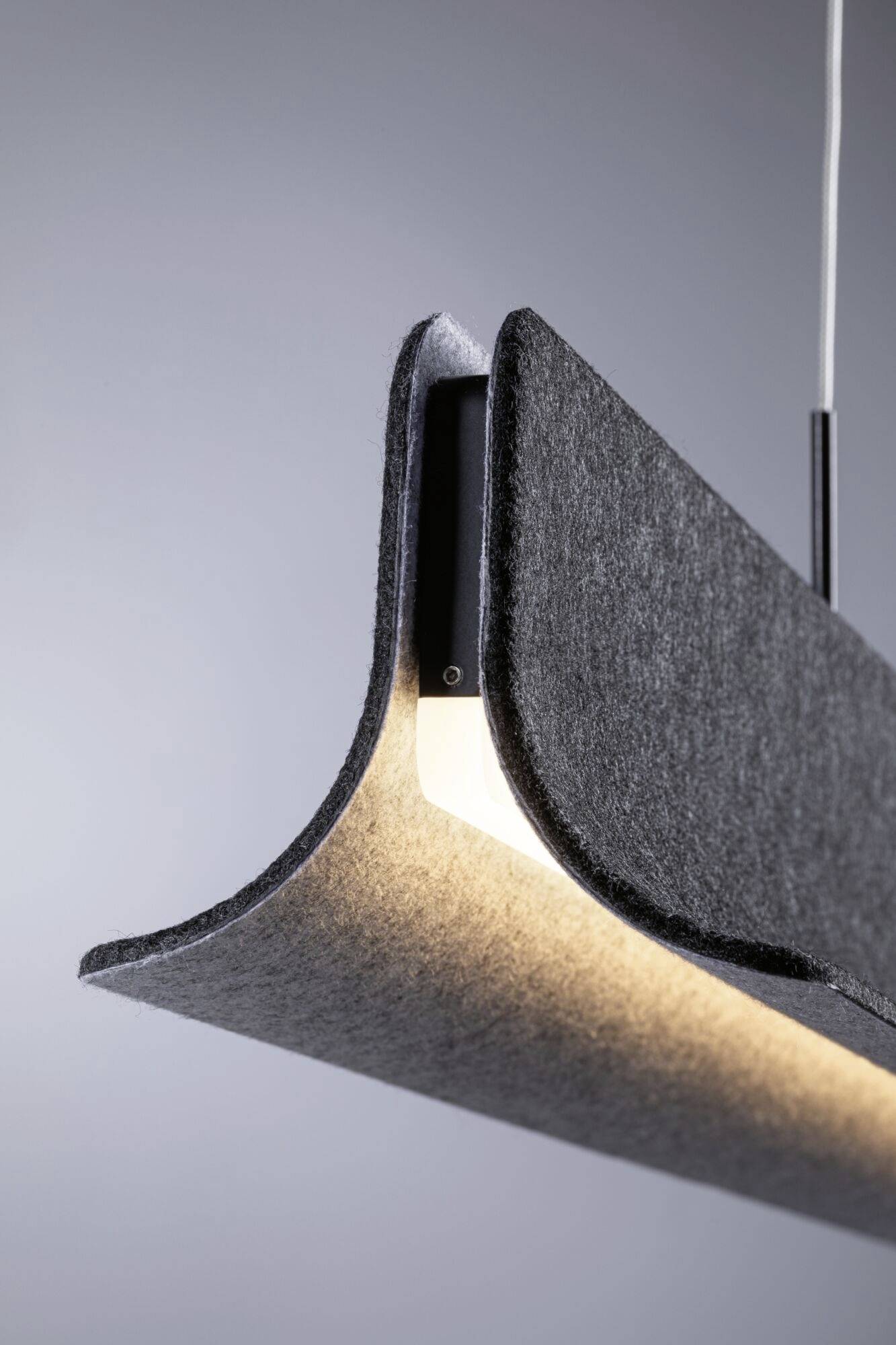 Lampada sospesa grigia moderna dal design curvo che illumina l'ambiente.