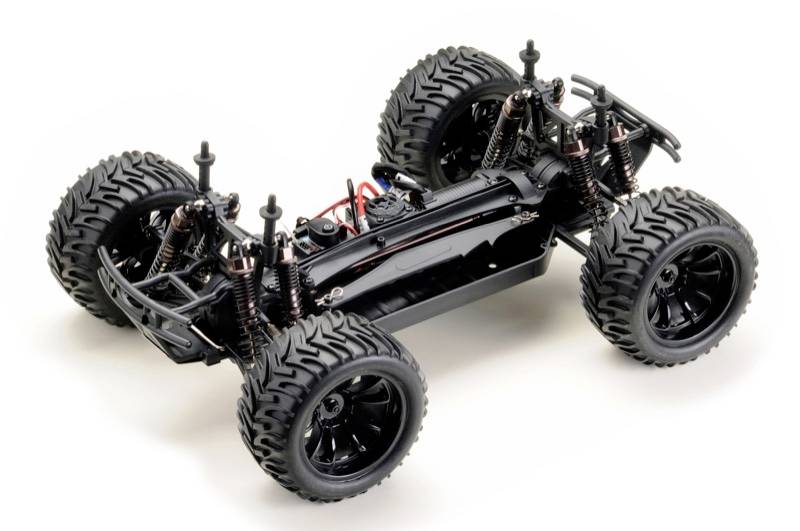 Un telaio di un'auto radiocomandata senza carrozzeria, mostra le sospensioni, gli pneumatici e la disposizione del motore. Ideale per gli appassionati di modellismo.