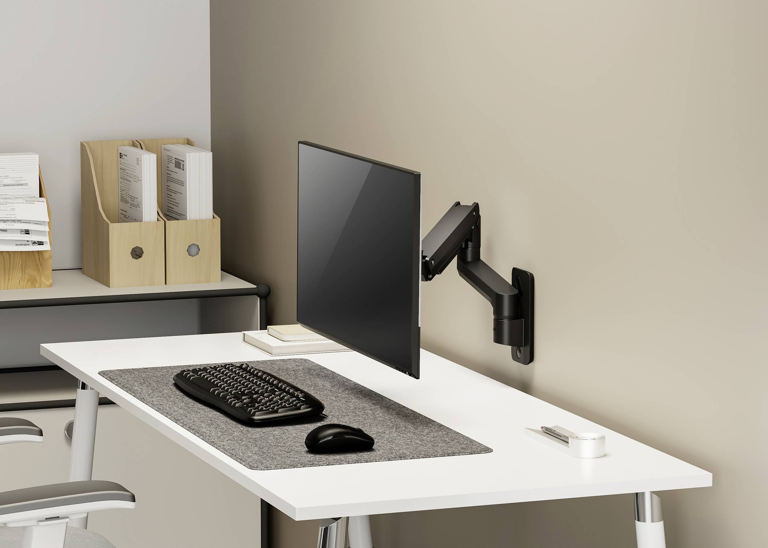 Una scrivania moderna e ordinata con schermo del computer su un supporto, tastiera, mouse e cartelle per ufficio sullo sfondo.