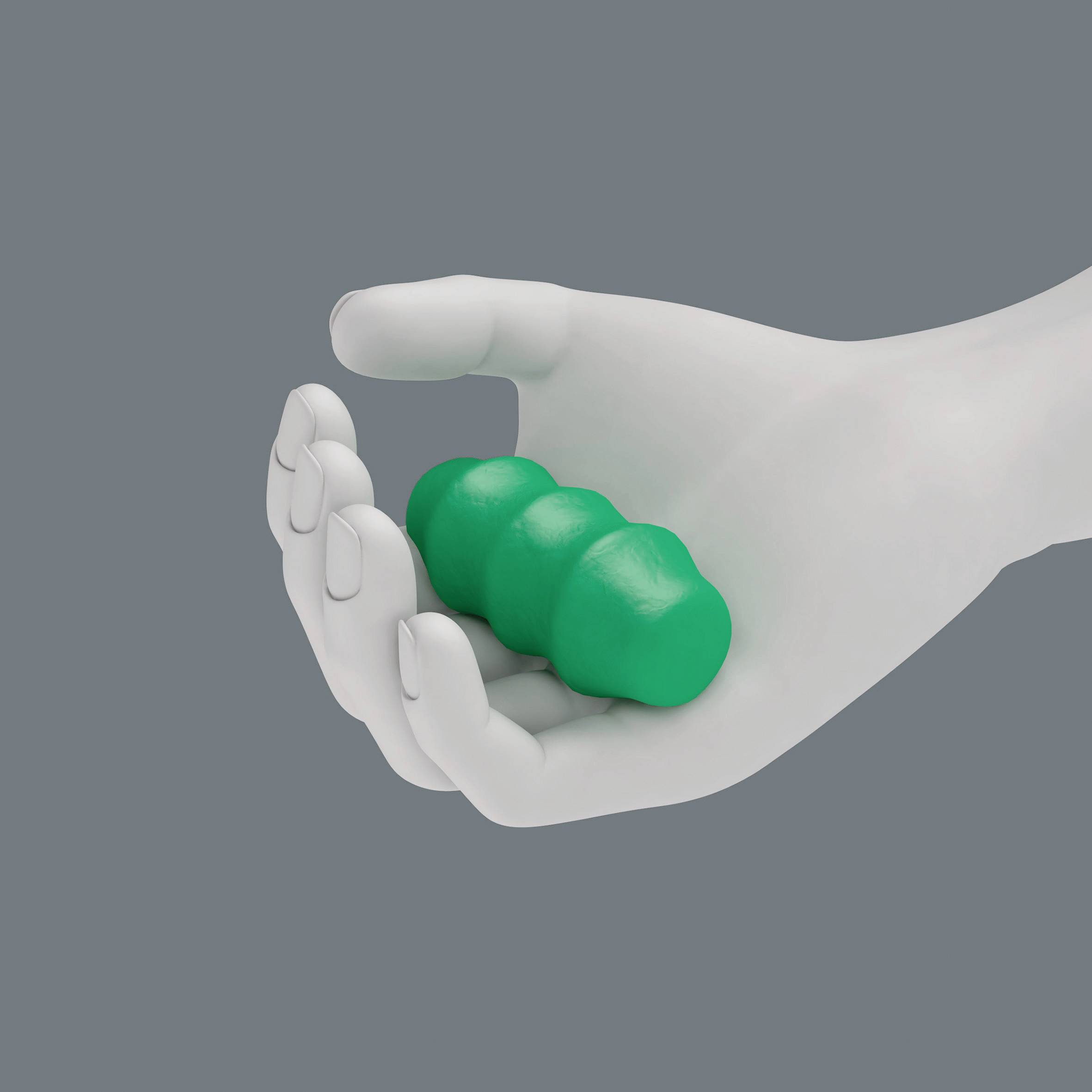 Una mano bianca tiene un oggetto verde di plastilina su uno sfondo grigio.