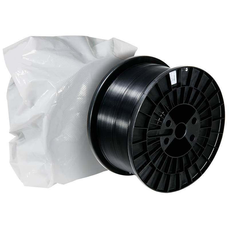 Bobina di filamento nero in plastica accanto a un imballaggio bianco chiuso.