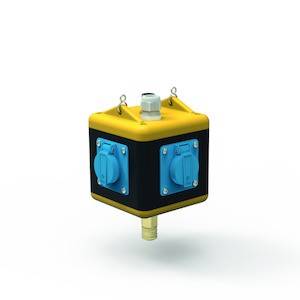 Un cubo giallo e nero con prese blu e un raccordo sulla superficie superiore, che galleggia al centro di una superficie bianca.