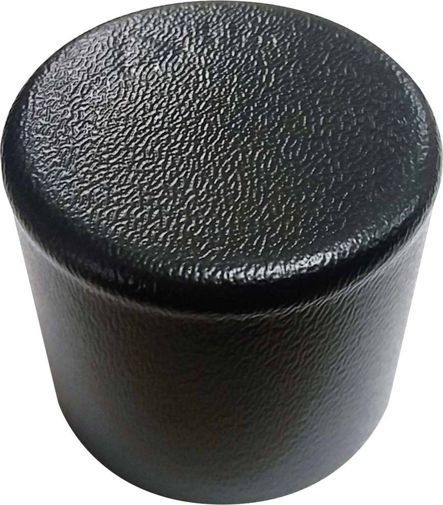 Un coperchio nero cilindrico in plastica con superficie testurizzata, visto dall'alto.