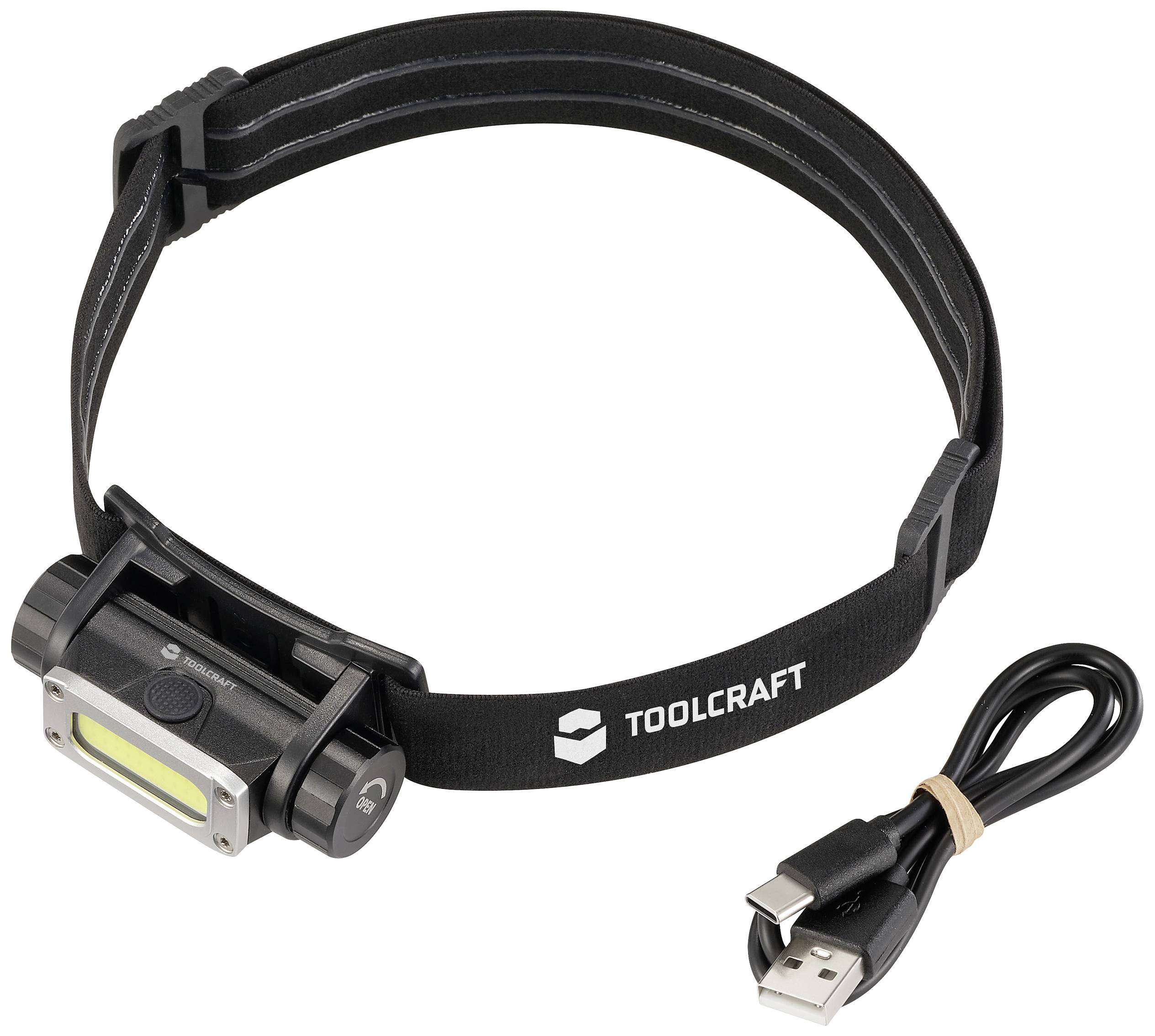 Una lampada frontale nera con stampa 'TOOLCRAFT', accanto a un cavo di ricarica USB. Ideale per l'uso a mani libere al buio.