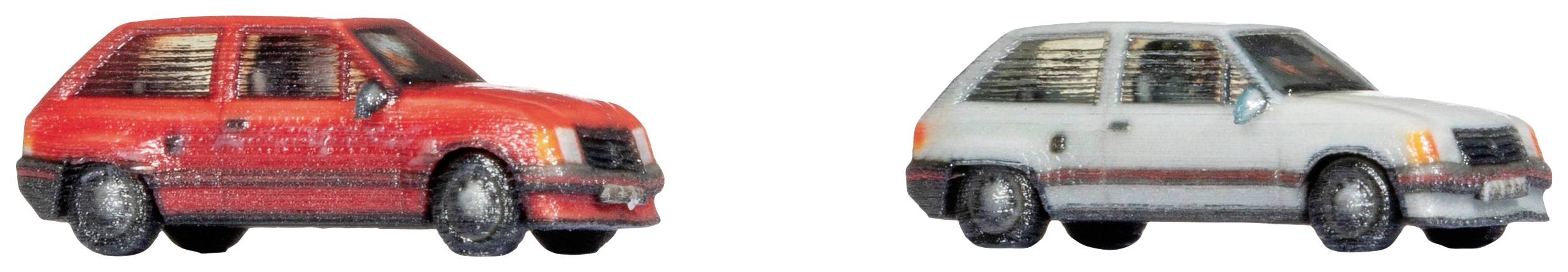 Due miniature di auto, una rossa e l'altra grigia, poste una accanto all'altra su uno sfondo bianco.