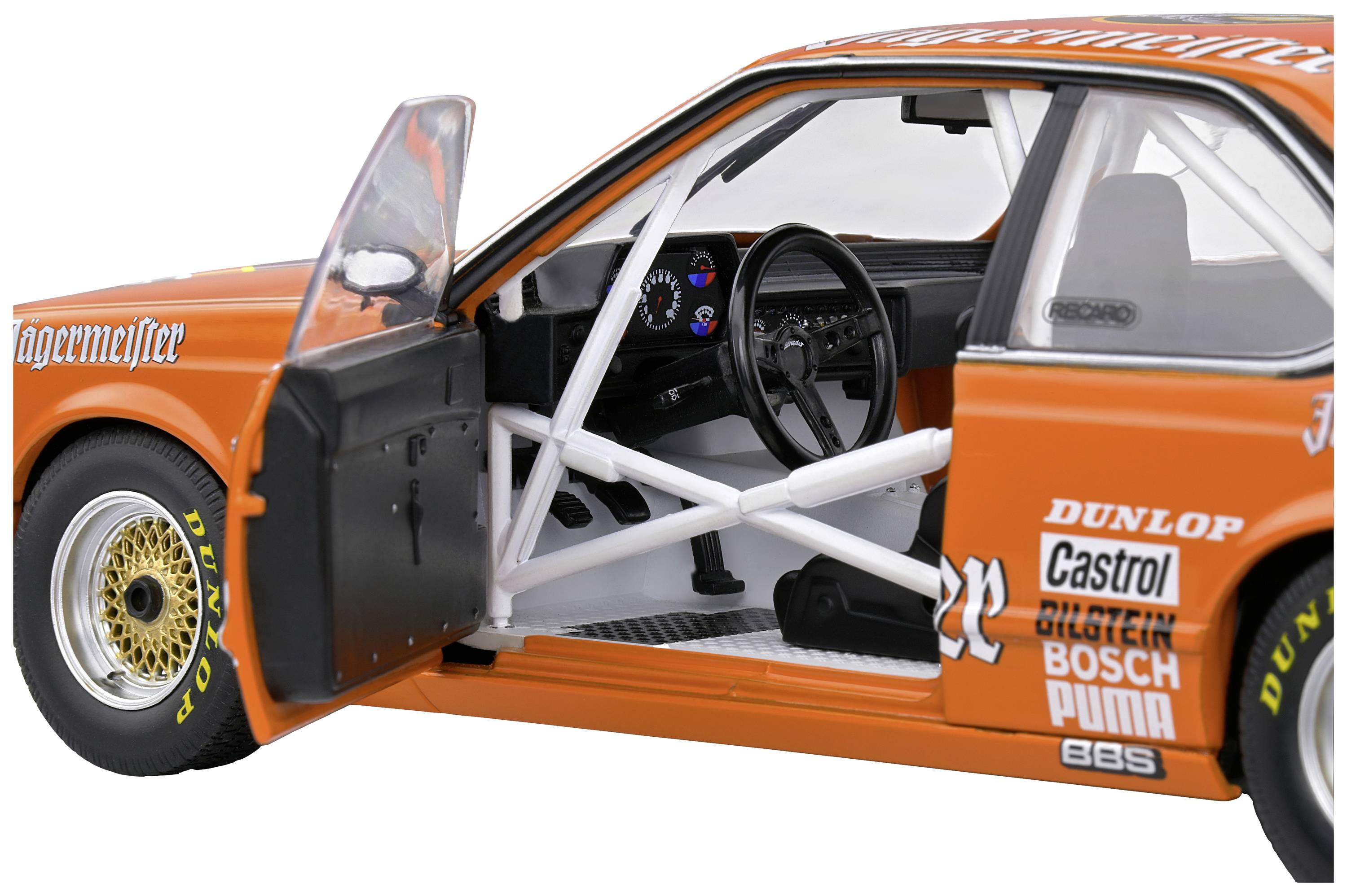 Un modello di auto da corsa arancione con la portiera del pilota aperta. La vista interna mostra la gabbia di sicurezza e il volante. L'esterno è decorato con i loghi degli sponsor.