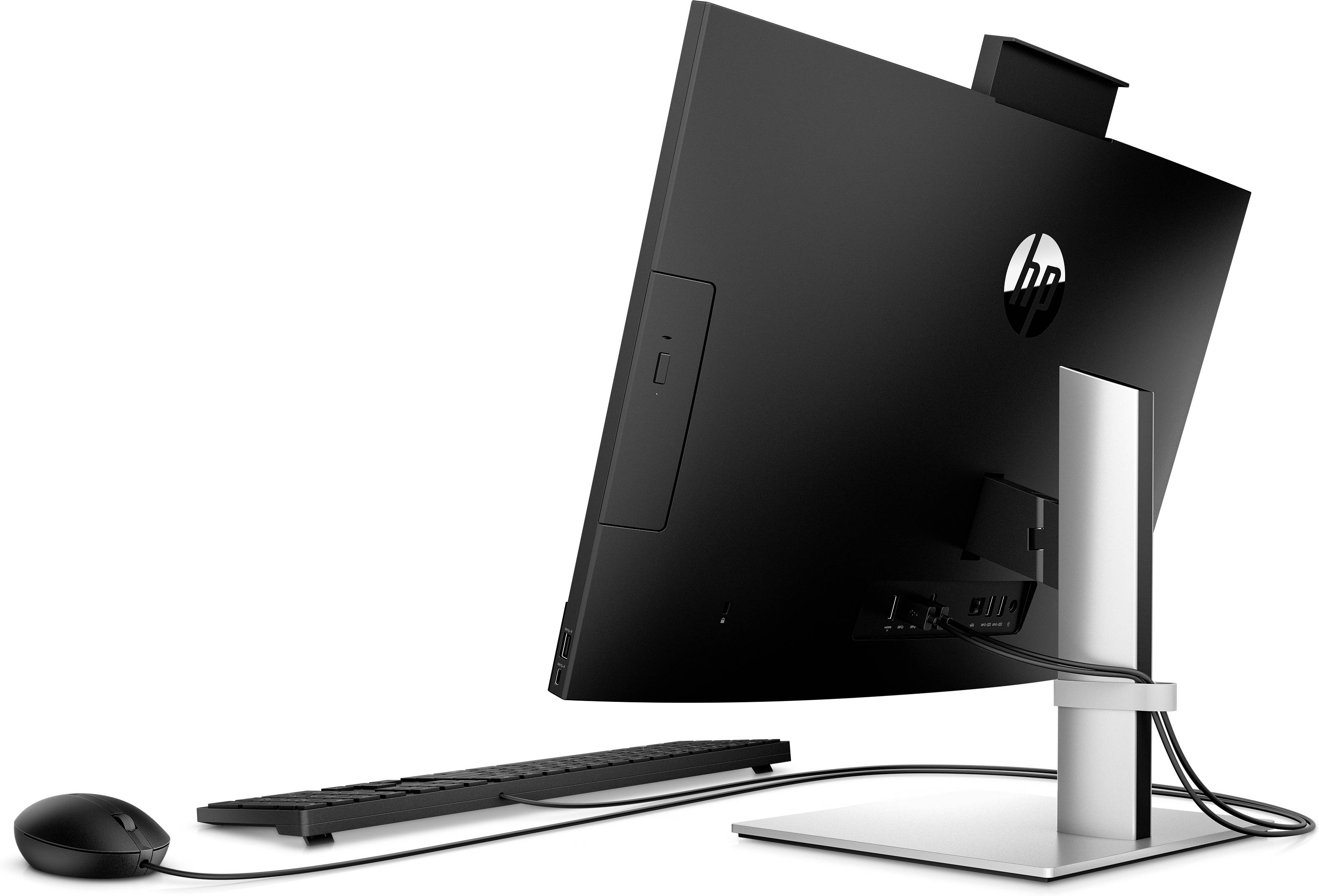 Un monitor nero è montato su un supporto argentato, con una tastiera e un mouse sul tavolo.