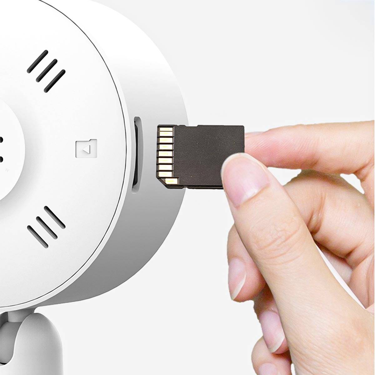 Una mano inserisce una scheda microSD in una fotocamera bianca montata a parete.