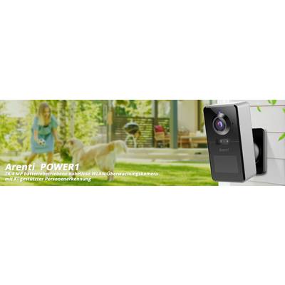 Telecamera di sorveglianza Arenti POWER1 montata a parete, sullo sfondo sfocato un bambino e un cane in giardino.