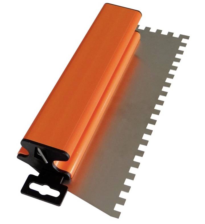 Un attrezzo per stuccare piastrelle arancione con bordo metallico dentellato, utilizzato per distribuire la colla durante la posa delle piastrelle.