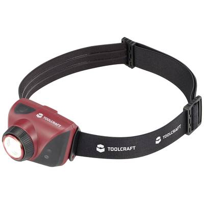 Lampada frontale rossa con fascia elastica nera con la scritta 'TOOLCRAFT'. Vista frontale con luce anteriore accesa.