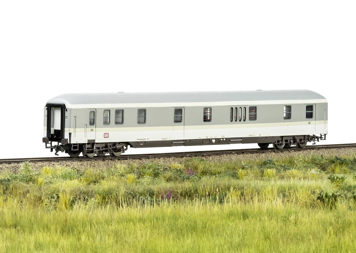 Vagone ferroviario in un paesaggio verde, fermo sui binari. Il treno ha un design semplice e moderno.